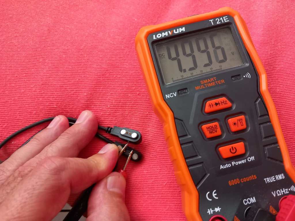 Comparativa de dos cables de carga magnéticos para gafas inteligentes con pines desplazados.